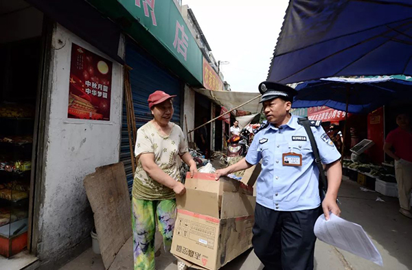 西安市公安局新城分局韩森寨派出所副所长汪勇帮助一位社区群众搬运物品。 李一博 摄