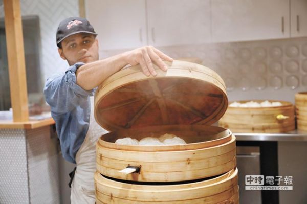 美国波士顿哈佛广场的包子店，店员取出蒸好的包子。（台湾中时电子报）