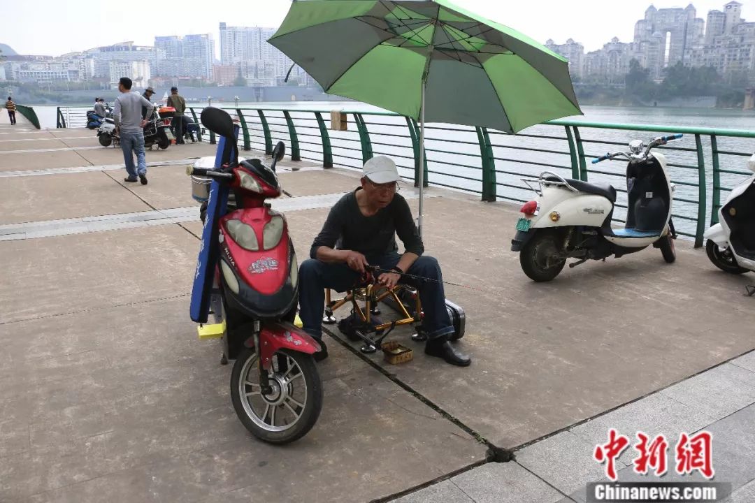 3月15日,柳州市钓鱼爱好者直接将电动车摆放在洞口,边坐在电车上边