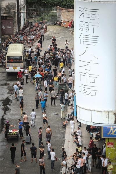 　　8月14日早晨5点40分，海新信人才市场旁的街道上，已经围满了前来“抢”薪水日结工作的打工者。本版采写、摄影/新京报记者 彭子洋