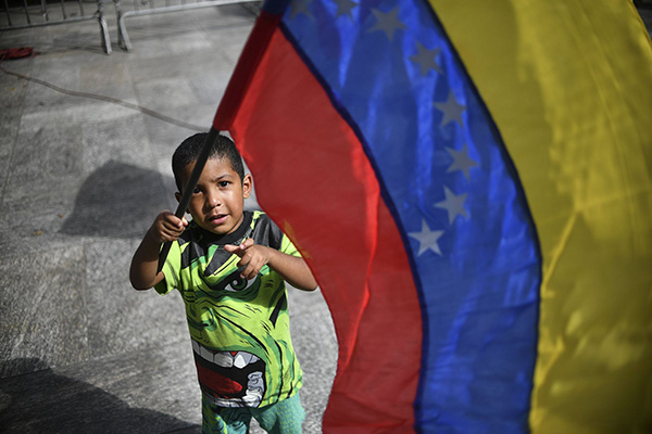 一名委内瑞拉男孩挥舞国旗。视觉中国 图