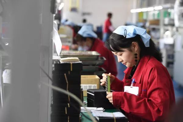 ▲资料图片:2019年4月16日,在汉中锐杰电子江湾移民社区扶贫工厂,工作人员在检验车用电子元器件。(新华社)