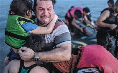 近日，一位来自叙利亚的父亲抵达希腊科斯岛后，抱着孩子喜极而泣，他们乘坐的偷渡船途中差点沉没。这张照片在推特上引发疯狂转发，有人写道：“给那些攻击‘移民’的人看看。”