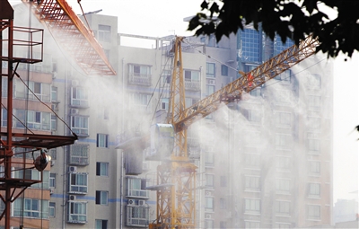 为降低工地扬尘，郑州部分工地塔吊铺设“淋浴”系统，喷水雾降尘。 图/CFP