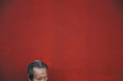 10月4日，故宫，一位游客身后的红墙上被人画上了心形图案。新京报记者 王嘉宁 摄