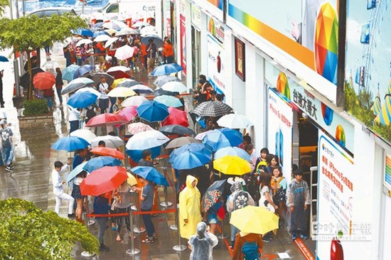 昨日iphone 6s开卖，即使下着大雨，仍有许多撑伞或穿雨衣的果粉排队换购新手机。（图自台湾“中时电子报”）