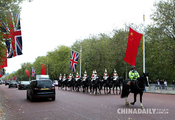 10月17日，在英国伦敦，一队骑兵从悬挂着中、英两国国旗的林荫路上经过。应英国女王伊丽莎白二世邀请，中国国家主席习近平将于10月19日至23日对英国进行国事访问。（新华社记者 韩岩 摄）
