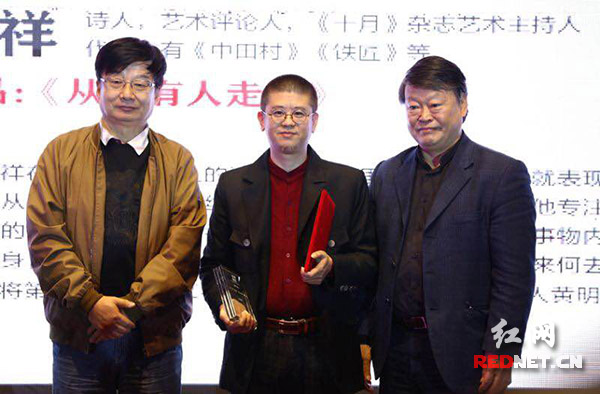 叶延滨(左)唐晓渡(右)为黄明祥(中)颁奖.