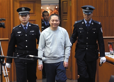 昨日，潜逃14年的仲加杰进入法庭时，笑着跟亲属打招呼。新京报记者 王贵彬 摄