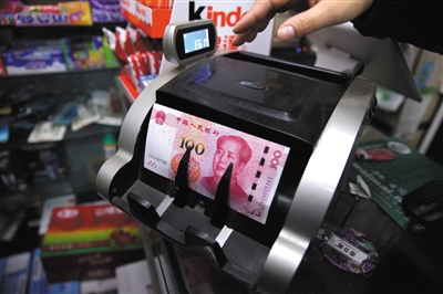 昨日，慈云寺一家超市，工作人员将新版百元纸币通过验钞机时，提示“纸币有疑问”。