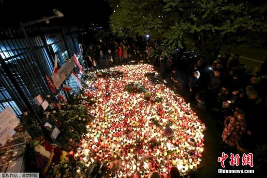 波兰华沙，哀悼的人们在法国大使馆外摆满了蜡烛。