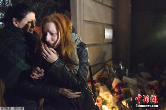 美国纽约，两名女子在法国领事馆前流下了悲伤的泪水。