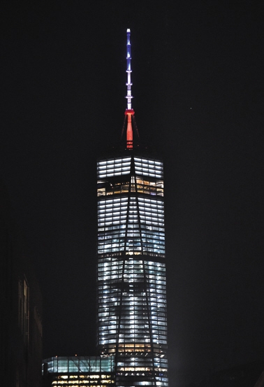 11月13日，美国纽约，新世贸中心点亮蓝、白、红灯光，纪念巴黎恐怖袭击遇难者。