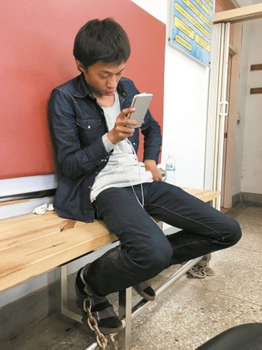 大货车司机陈君玮，在派出所滑手机。图自台湾《联合报》
