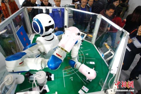 资料图：2015世界机器人大会此前在北京开幕，展示世界机器人最新研究、应用重点领域以及智能社会的创新发展。图为自动发牌机器人。 中新社记者 富田 摄