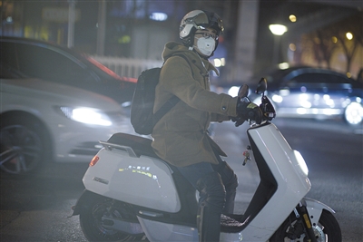 昨晚，蒲黄榆，一名路人戴口罩骑行。新京报记者 王嘉宁 摄