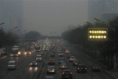昨日下午4时30分，国贸桥，路边显示屏提示“双号车辆行驶”。北京市启动空气重污染红色预警，全市范围内单双号限行。A06-A07版摄影（除署名外）/新京报记者 薛珺 吴江 浦峰 卢淑婵