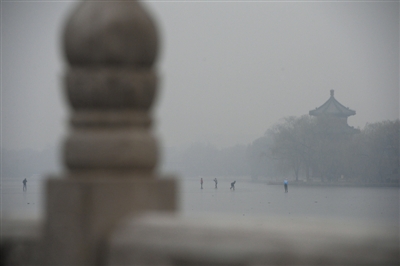 昨日上午10时许，后海，几位市民在雾霾中滑冰。
