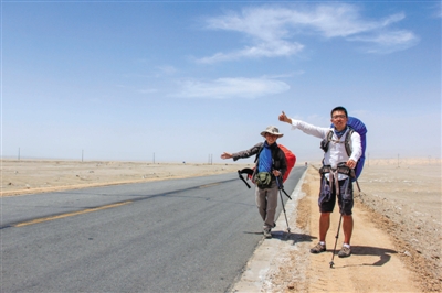 7月27日,李振与旅伴在青海的公路上搭车准备去若羌。