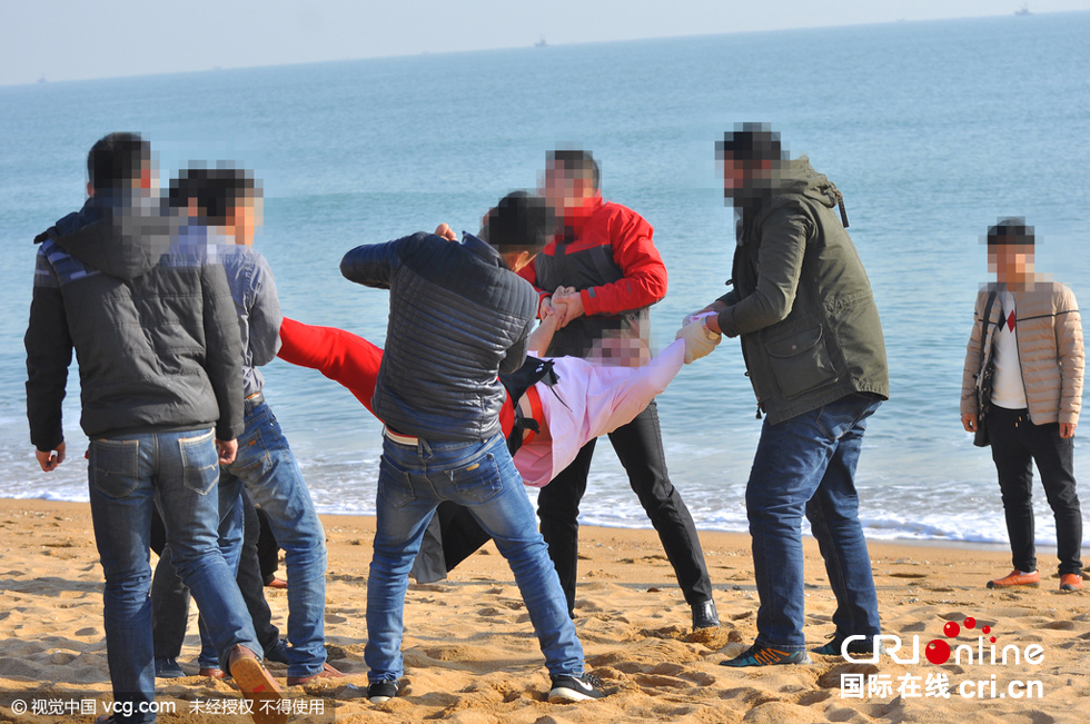 山东日照海边上演婚闹 新郎被扒掉棉衣扔进大