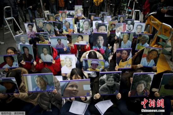 资料图：2015年12月30日，韩国首尔，当地民众手中高举慰安妇受害者照片，在日本使馆前集会抗议。