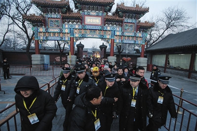 昨日，雍和宫大街，早7时，安保人员手挽手在前排引导香客们从大门走向售票处。当天是大年初一，大批游客与信众前往雍和宫烧香祈福。本版摄影/新京报记者 彭子洋