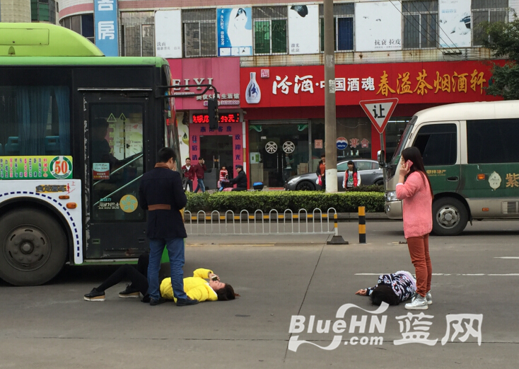 两名女子横卧在马路中央，行驶的车辆不得不绕行