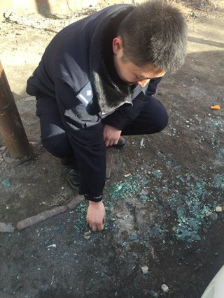 民警指认案发被砸碎玻璃。新京报记者 左燕燕 摄