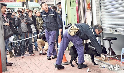 劫杀案发生后，警方封锁兑换店调查及召来追踪犬协助搜证，其间有途人驻足围观。（图自香港《明报》）