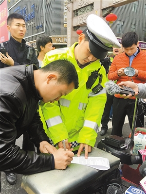 昨日，福华路，一名男子在查扣单上签字。深圳商报记者 肖兵峰 实习生 杨卫卫 摄