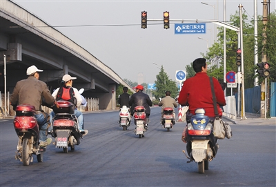 2014年5月，北二环与和平里西街交叉口，一群骑电动车的市民闯红灯而过。 新京报记者 尹亚飞 摄