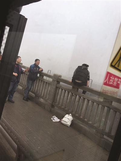 女子坐在大桥栏杆上。