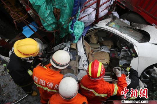 小轎車被壓在一輛大貨車下 姬棟 攝