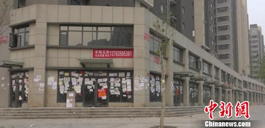 20多间商铺被贴近万张小广告，“霸气广告墙”由此得名。 李超庆 摄