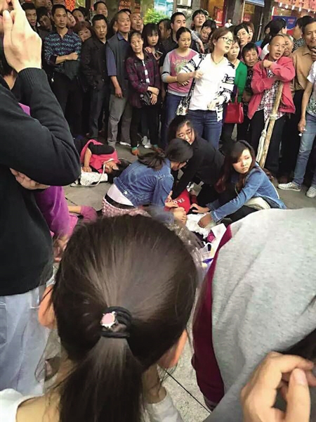 人和125路公交车站附近,4名女孩在对老太施救。