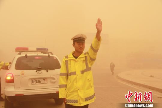 图为若羌县交警早沙尘中执勤。 何若楠 摄