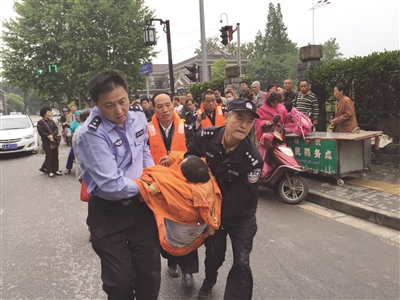 民警抬着溺水男子奔向警车准备送医。警方供图