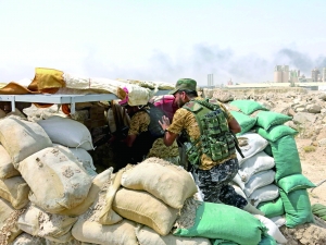 近日，在伊拉克费卢杰市郊，支持伊拉克政府的什叶派民兵组织“人民动员组织”军事人员进入掩体。新华社发