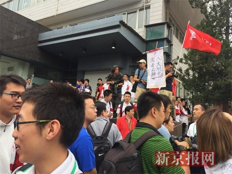 一名校友举着“人大附中,高考必胜”的小牌为考生加油。新京报 吴为 摄