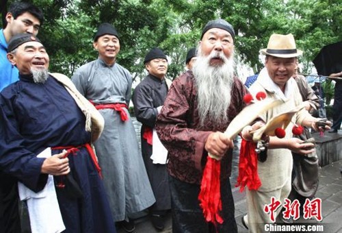 资料图： 北京后海小广场内，民俗表演区里“戏曲、叫卖、空竹、舞蹈、诗会”等以端午为题材的传统表演你方唱罢我登场。图为民间艺人表演牛骨数来宝。 王志堃 摄