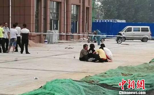 图为女大学生坠楼现场拉起了警戒线，家属席地而坐悲痛欲绝。