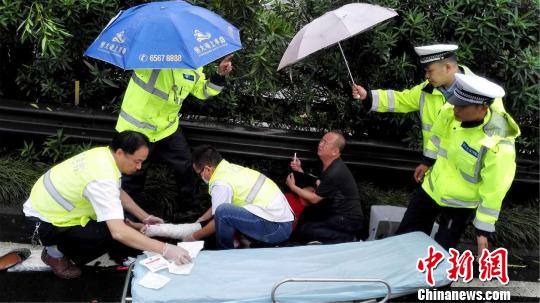 民警为伤者撑雨伞。 曾华振 摄