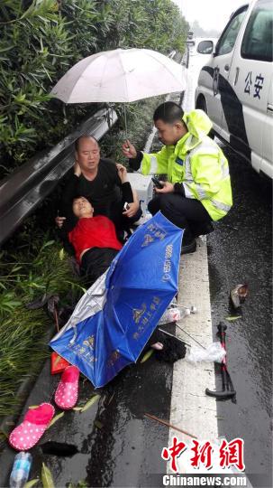 民警为伤者撑雨伞。 曾华振 摄