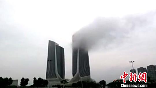 图为22日上午，南京超高层建筑青奥双子塔被云雾笼罩。 视频截图 摄