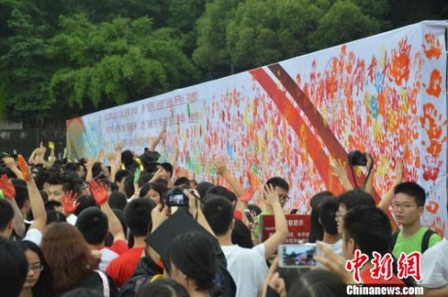 资料图：2014年6月24日，湖南大学2014届本科生毕业典礼在湖南大学南校区体育场举行，数千名毕业生以鞠躬、拥抱以及“涂鸦”的方式来抒怀自己对母校的感恩。向一鹏 摄