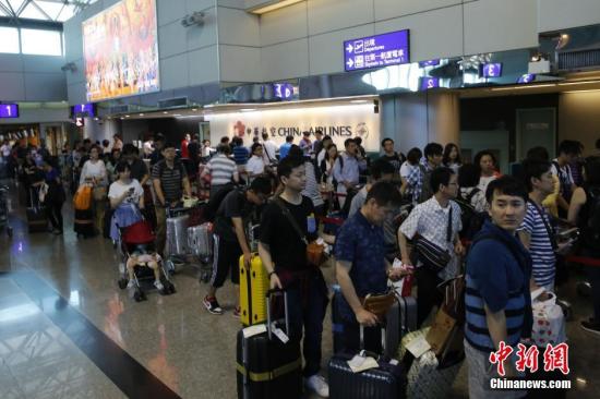 资料图:台湾桃园机场内,中华航空公司服务台前咨询航班信息或改签航班的旅客排起百余米的长队。 <a target='_blank' href='http://www.chinanews.com/'>中新社</a>记者 陈小愿 摄
