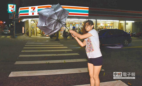 台东市区7日晚间出现间歇性强风骤雨，瞬间强风令行人举步维艰。（图：台湾《中国时报》/庄哲权 摄）