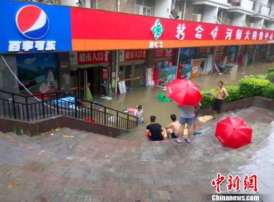 图为河南师范大学校园内商铺被淹，学生、商家被“困”在台阶上。 周小云 摄