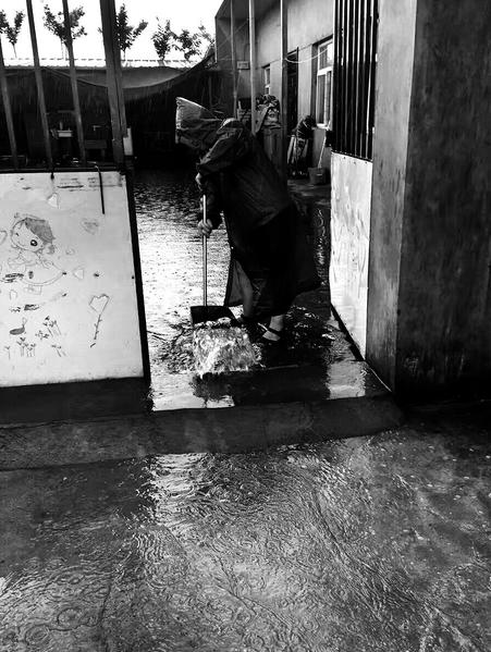 戶縣降雨,一農(nóng)戶清理積水 通訊員蔣宏本報(bào)記者代澤均攝