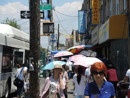 华裔民众出招对抗骄阳，缤纷的伞撑开8大道鲜有的伞海奇观。（美国《世界日报》/王靖雯 摄）